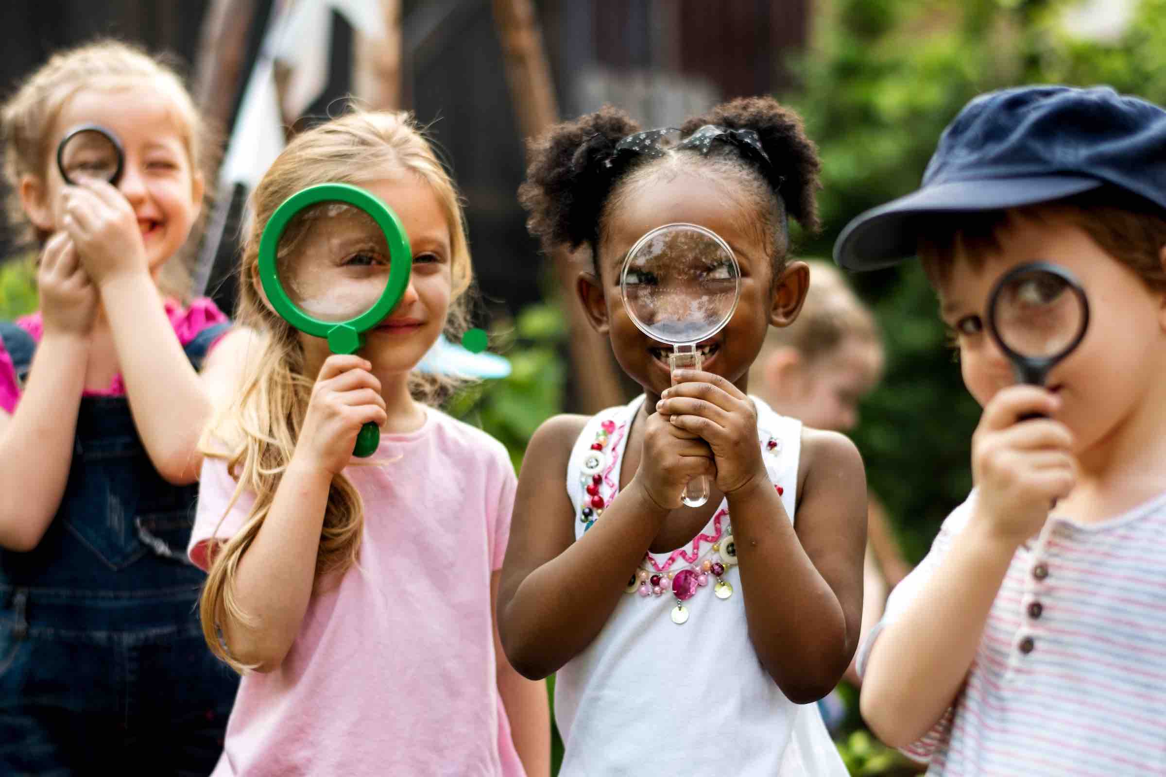Group of kindergarten kids friends holding magnifying glass for explore