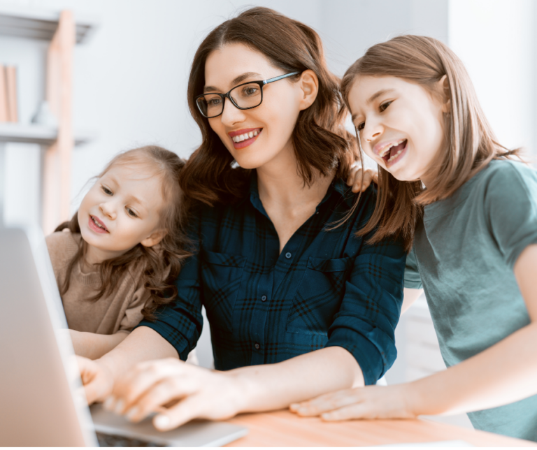 Mom sitting at a computer with a child on her left and right both looking at the computer