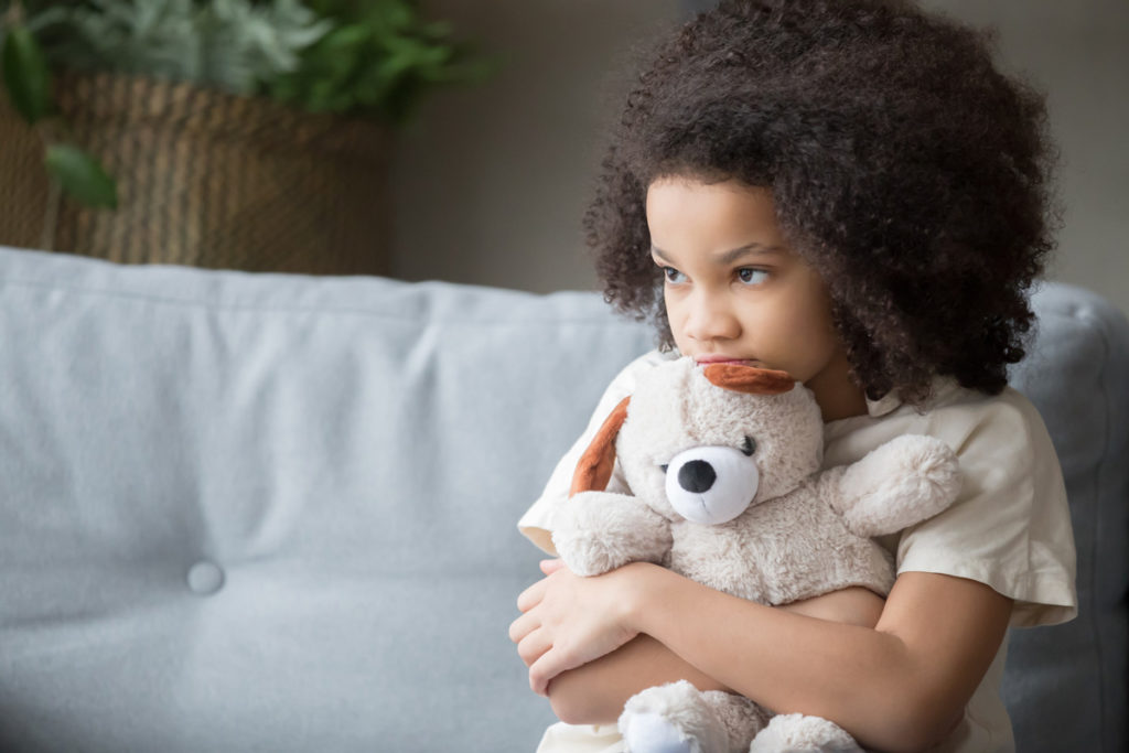 Bild eines jungen Mädchens, das einen Teddybär hält
