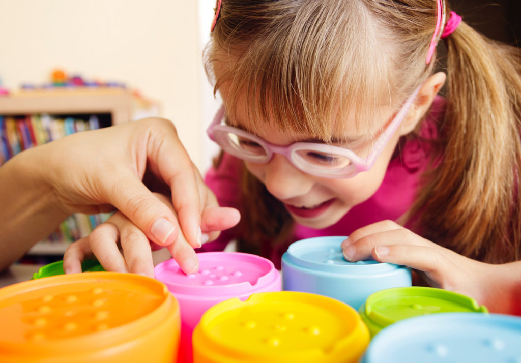 image of young girl with glasses lookignnglosely at textured cups