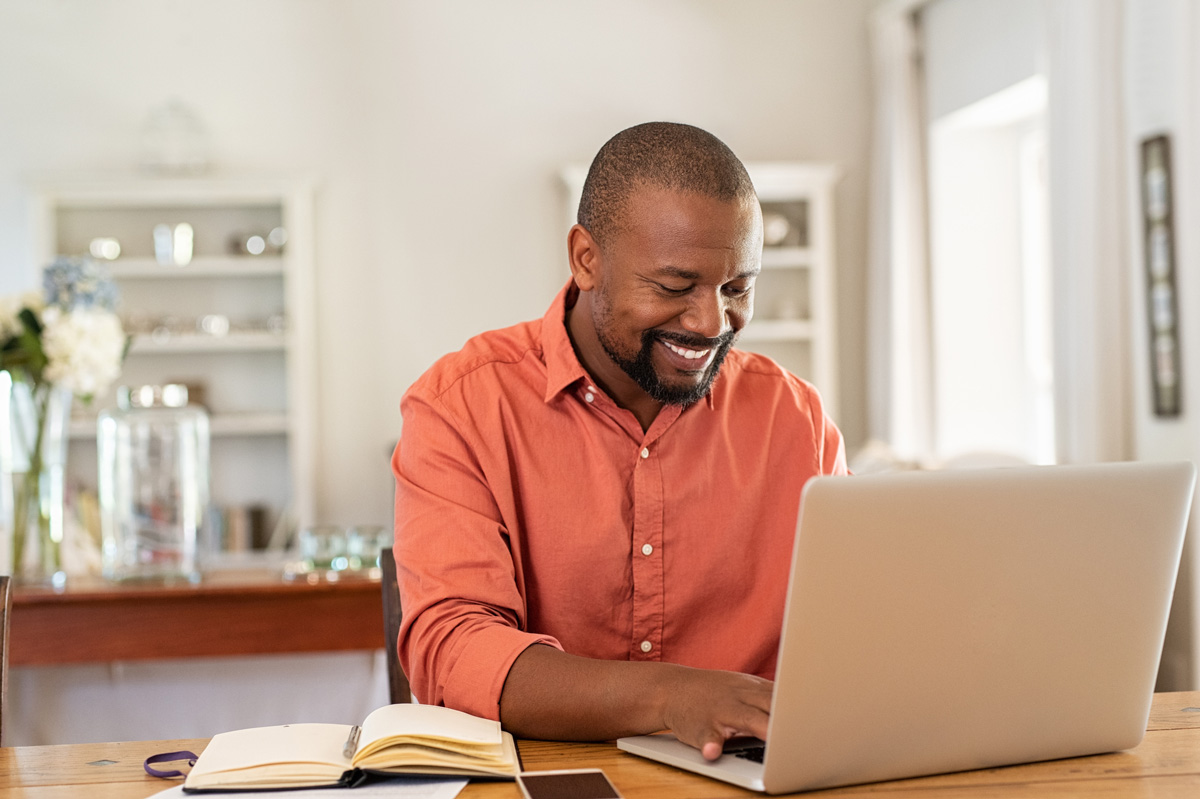 a dad making a donation on a laptop, happy