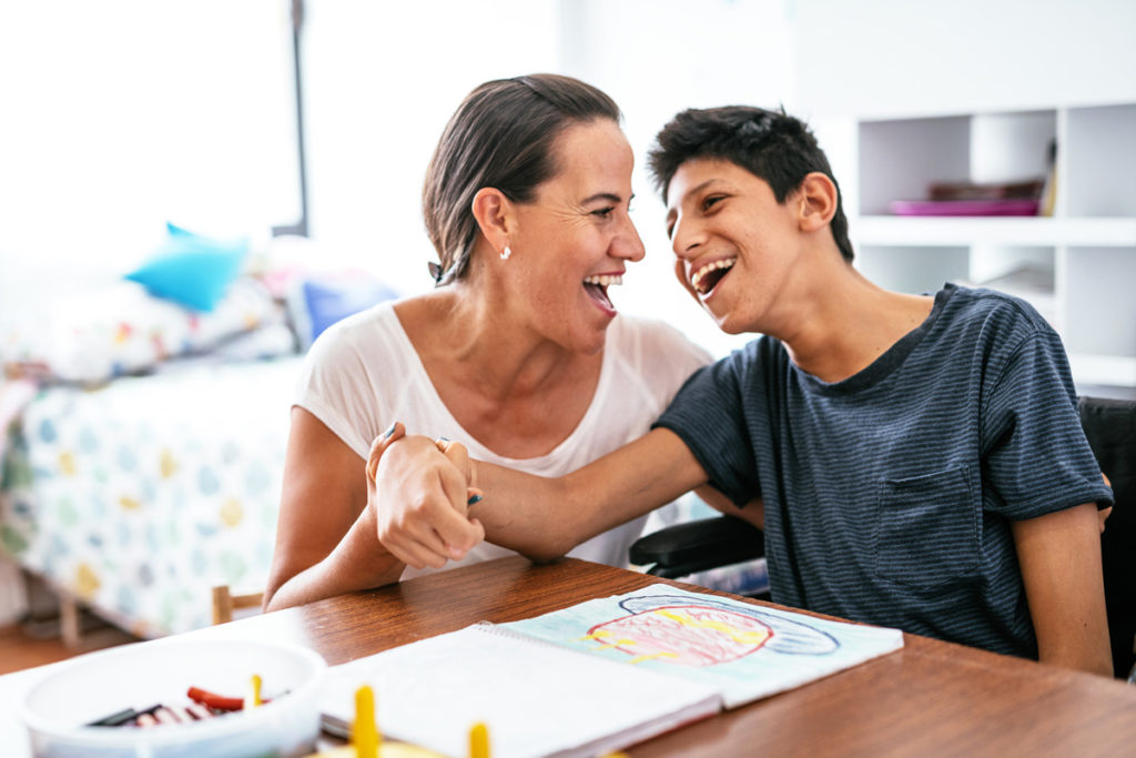 image of son coloring withe assistance from his mother