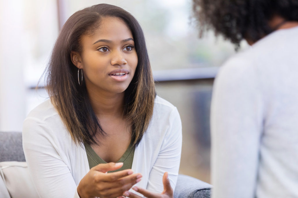 image of teenage girl explaining something to adult