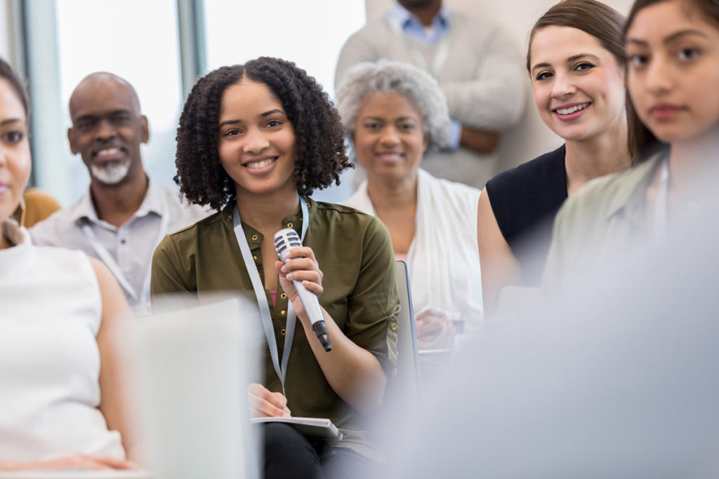 image of lady holding microphone standing among other adults