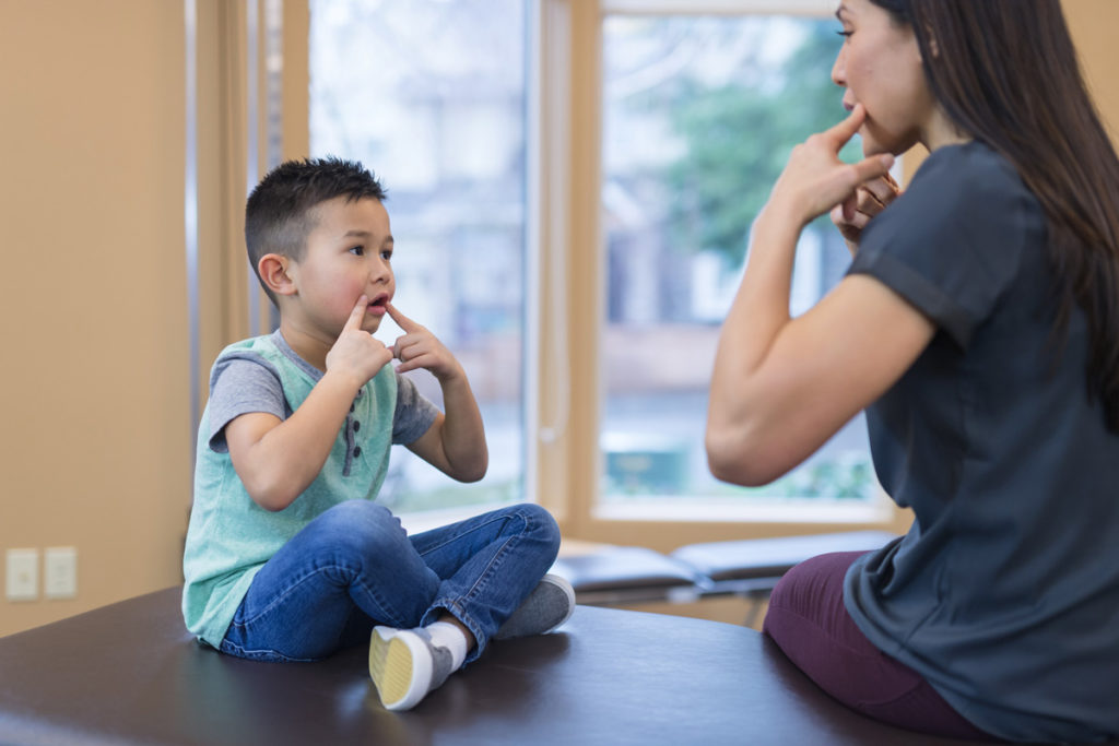 image of young Asian boy copying his mom