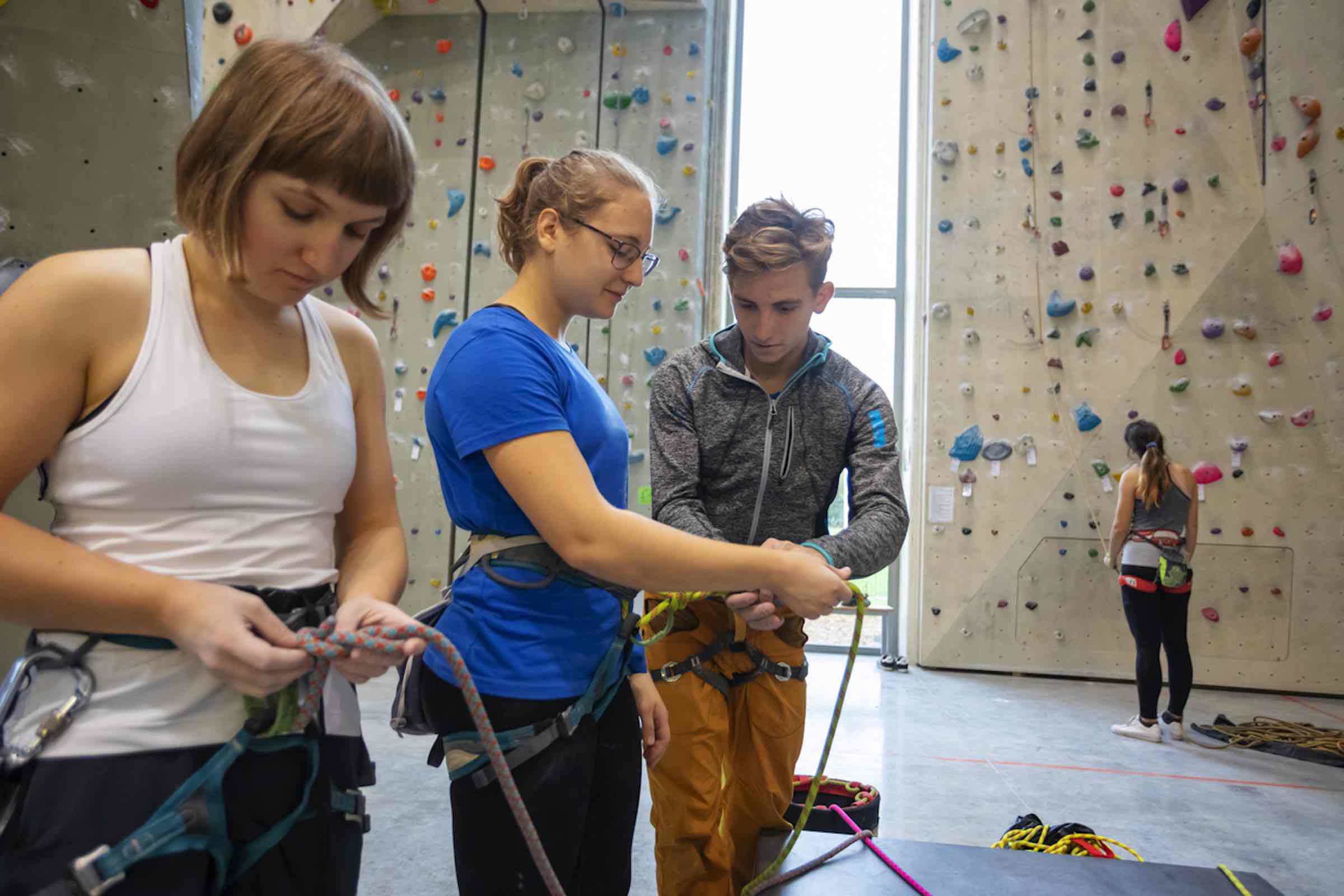 deaf female with friends at rock climbing wall